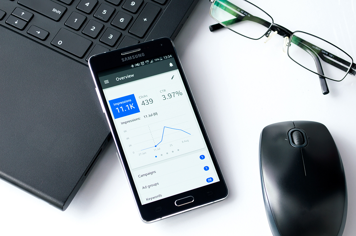 Mobile phone on desk shows analytics results from a digital add campaign