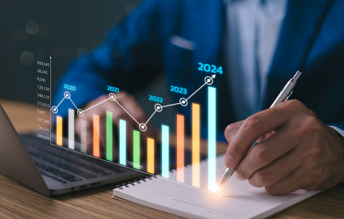 Businessman holding pen analyzes performance with virtual bar chart rising from his desk